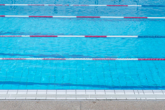 Piscina com água azul, separadores de raia e grelha na borda